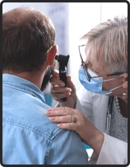 A doctor conducting an ear examination on a patient to assess their current condition.